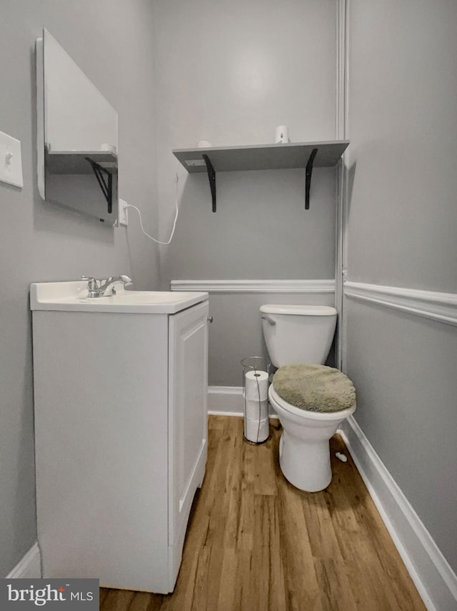 bathroom with hardwood / wood-style floors, vanity, and toilet