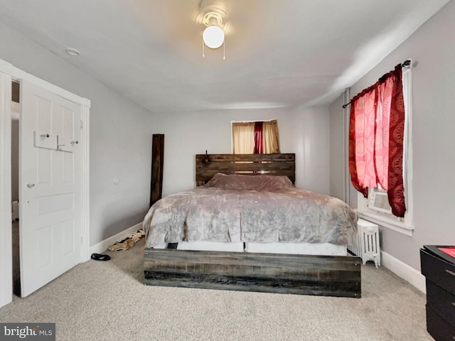 carpeted bedroom with radiator heating unit and ceiling fan