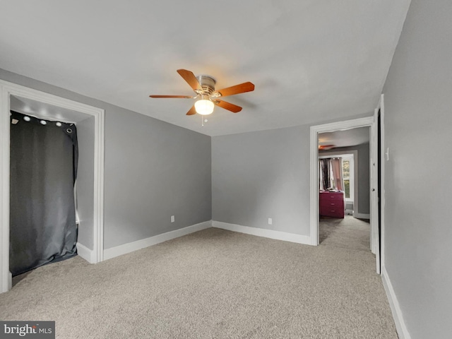 unfurnished bedroom with ceiling fan and light colored carpet