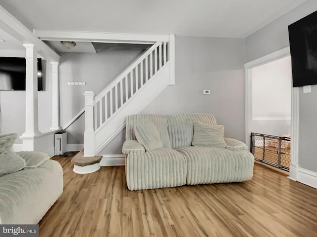 living room with light hardwood / wood-style flooring and decorative columns