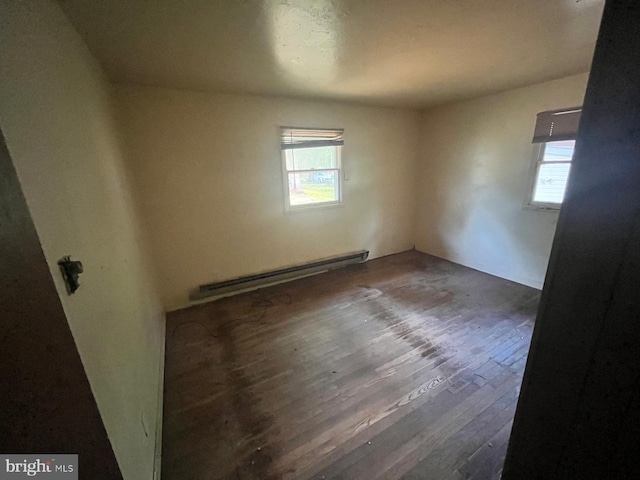 unfurnished room with a baseboard radiator and dark hardwood / wood-style flooring