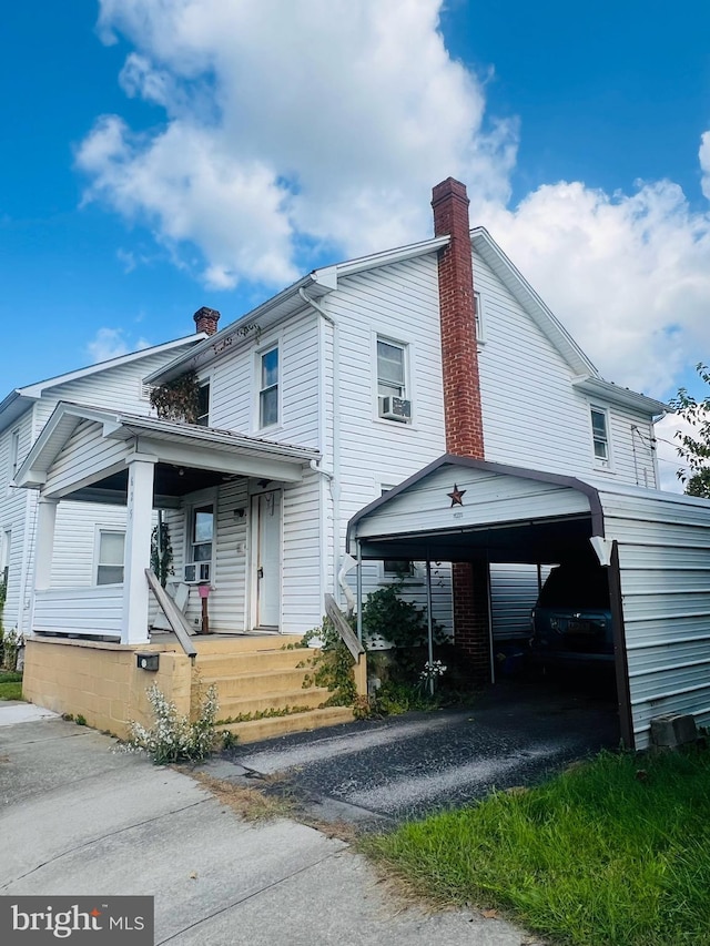 view of front of property with covered porch, cooling unit, and a carport