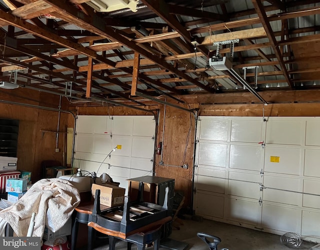 garage with a garage door opener and wooden walls