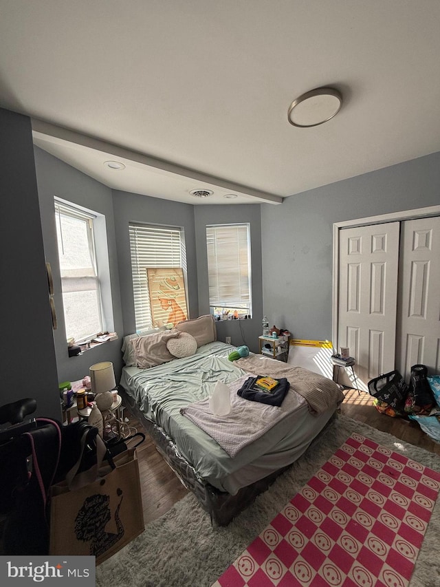 bedroom with a closet and dark hardwood / wood-style flooring