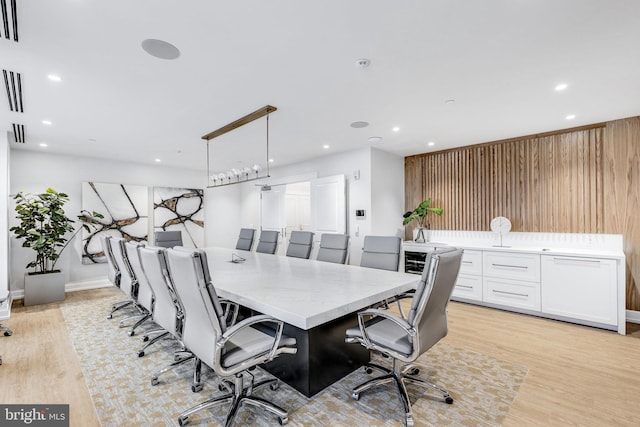 office with light hardwood / wood-style flooring and wooden walls