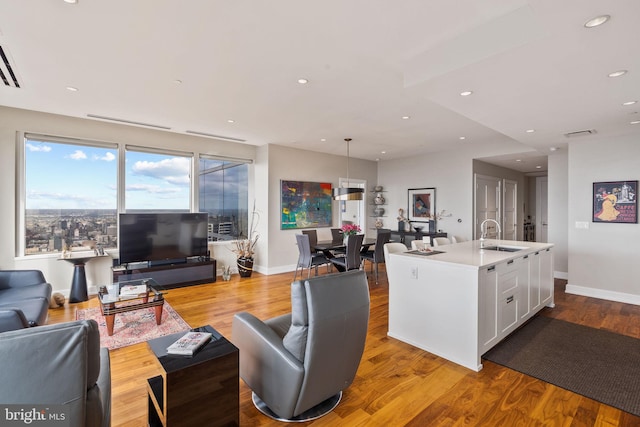 living room featuring light wood-type flooring and sink