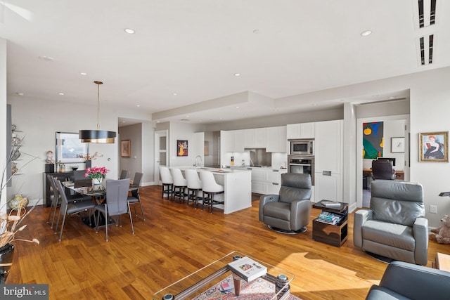 living room with light wood-type flooring and sink