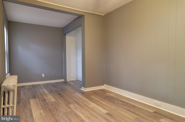 empty room featuring hardwood / wood-style flooring and radiator