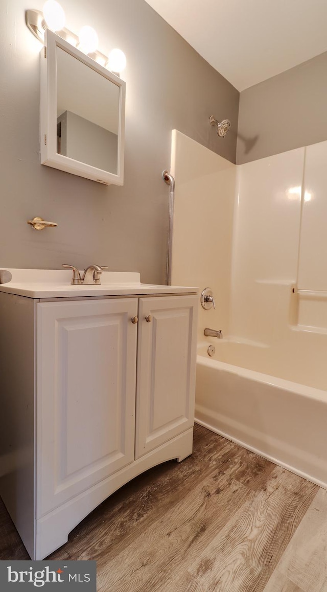 bathroom featuring hardwood / wood-style flooring, vanity, and tub / shower combination