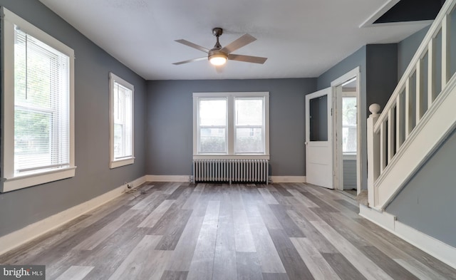 interior space with plenty of natural light, radiator heating unit, ceiling fan, and light hardwood / wood-style flooring