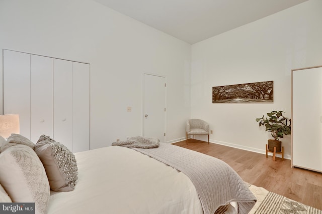 bedroom with light wood-type flooring and a closet