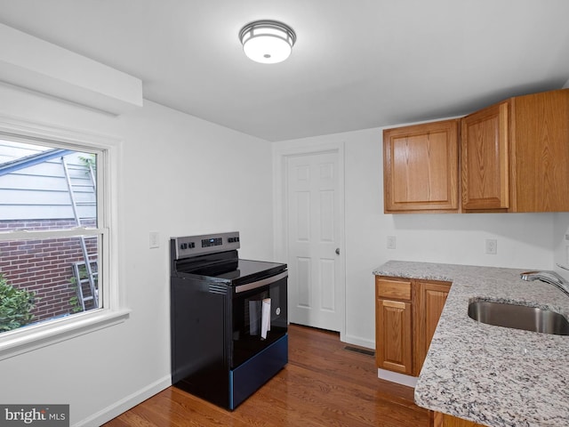 kitchen featuring dark hardwood / wood-style flooring, a wealth of natural light, black range with electric cooktop, and sink