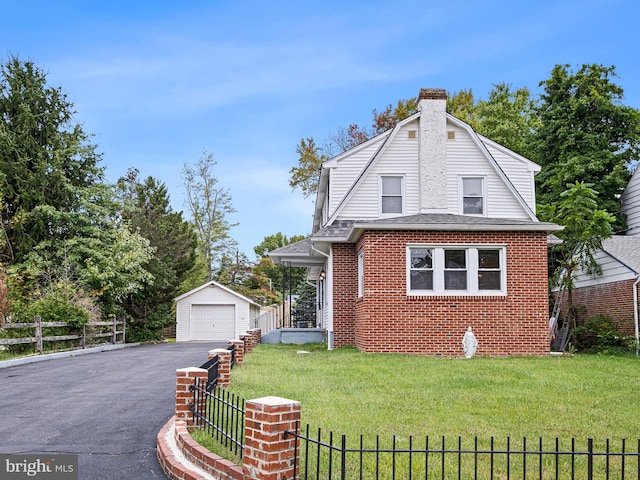 view of front of house with a front lawn, an outbuilding, and a garage