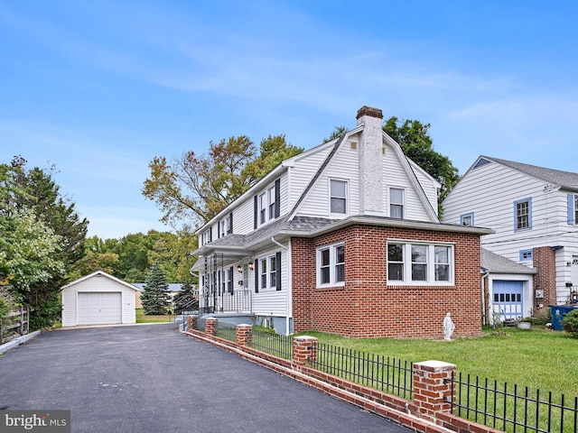 view of front of property with a front yard, a garage, and an outdoor structure