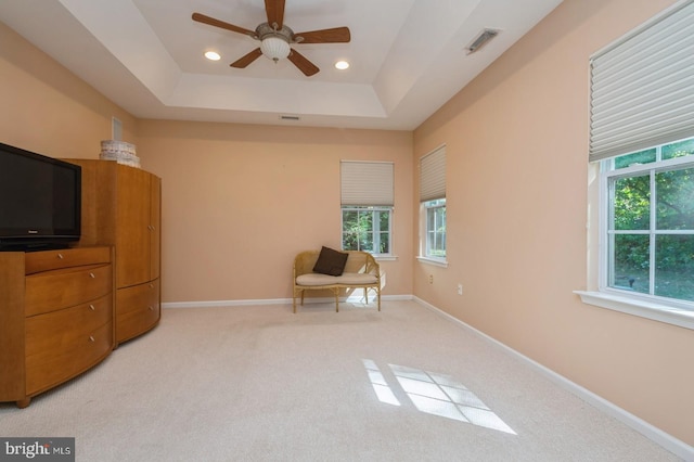 unfurnished room with ceiling fan, a tray ceiling, and carpet floors