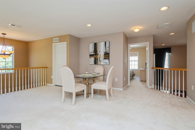 carpeted dining space with a notable chandelier