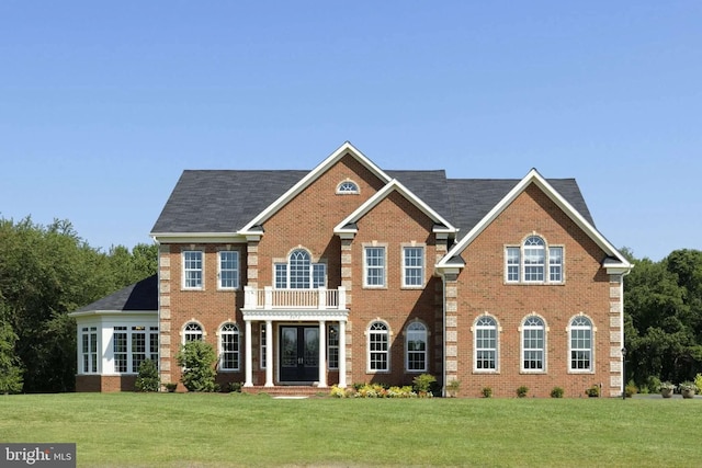 view of front of property with a balcony and a front lawn