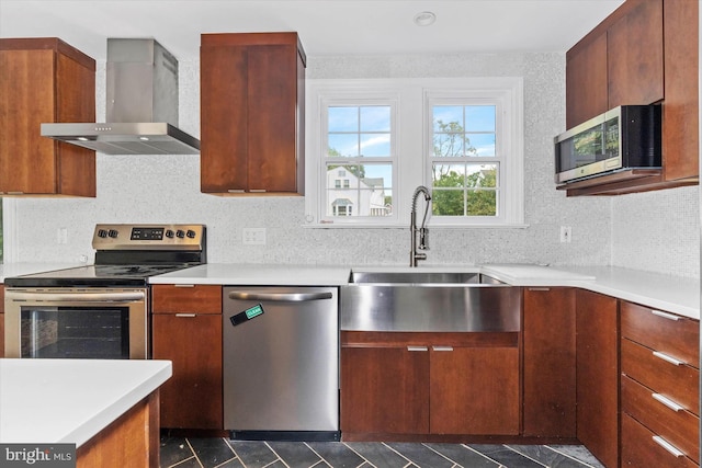 kitchen with appliances with stainless steel finishes, sink, wall chimney range hood, and tasteful backsplash