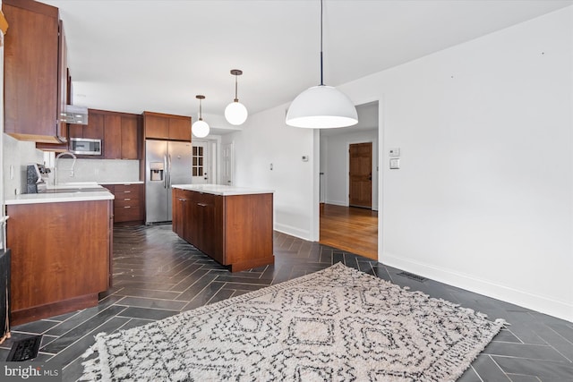 kitchen featuring backsplash, pendant lighting, stainless steel appliances, a center island, and sink