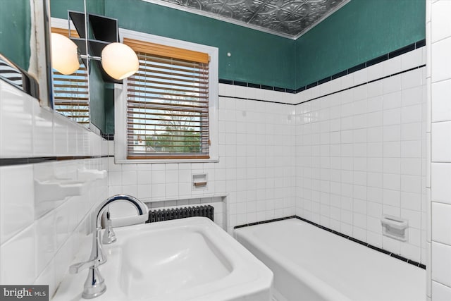 bathroom featuring tile walls and sink