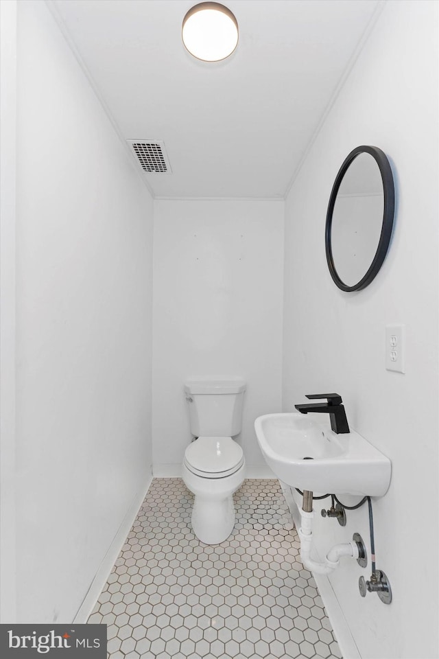 bathroom featuring sink, crown molding, toilet, and tile patterned floors