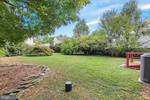 view of yard with central AC unit and a deck