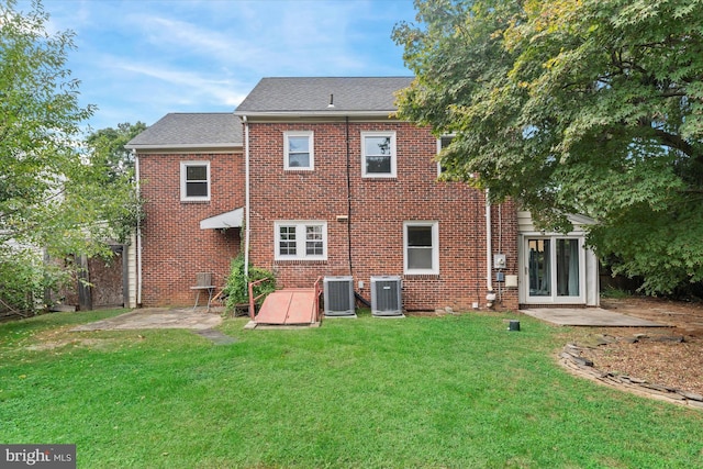 back of house featuring a lawn, central AC, and a patio area