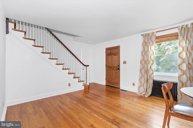 entryway with light wood-type flooring and radiator heating unit