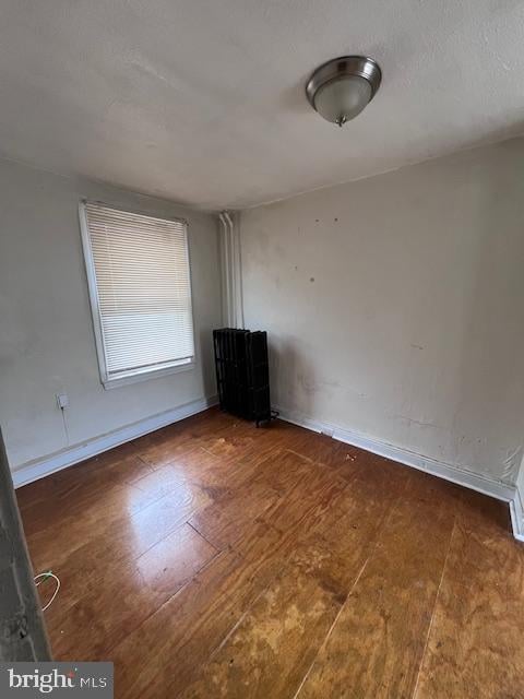 unfurnished room featuring dark hardwood / wood-style flooring