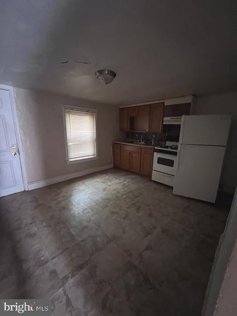 kitchen with ventilation hood, sink, and white appliances