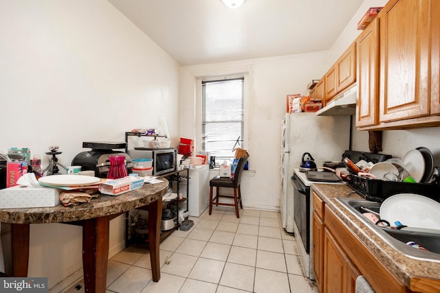 kitchen with white electric range oven, light tile patterned floors, and sink