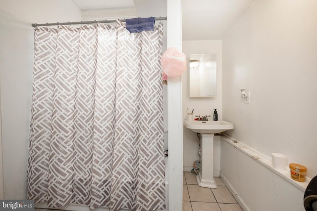 bathroom with a shower with curtain, tile patterned floors, and sink