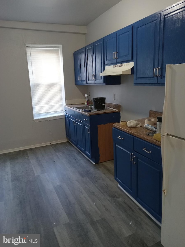 kitchen featuring blue cabinetry, white refrigerator, dark hardwood / wood-style floors, and sink