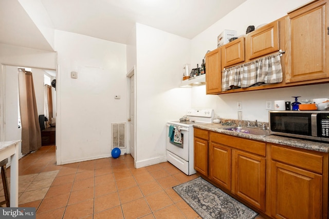 kitchen featuring electric range, light tile patterned flooring, and sink