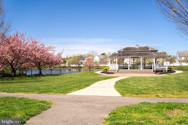 view of property's community featuring a lawn, a water view, and a gazebo