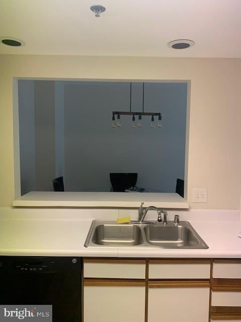 kitchen featuring black dishwasher, white cabinetry, and sink