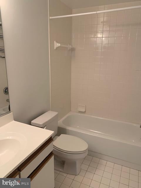 full bathroom featuring tile patterned flooring, tiled shower / bath, vanity, and toilet