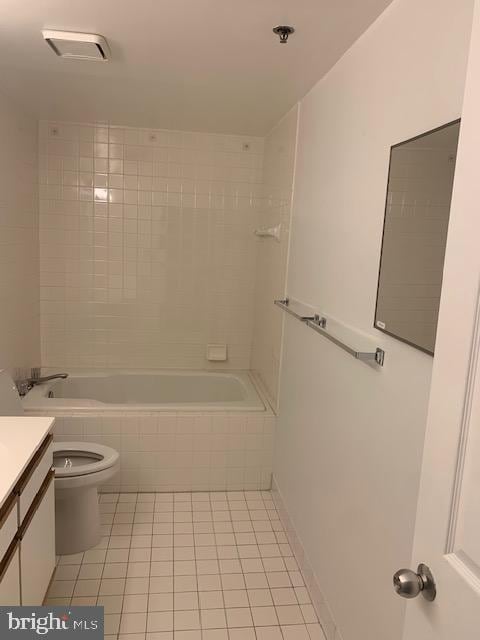 full bathroom featuring tile patterned flooring, tiled shower / bath, vanity, and toilet