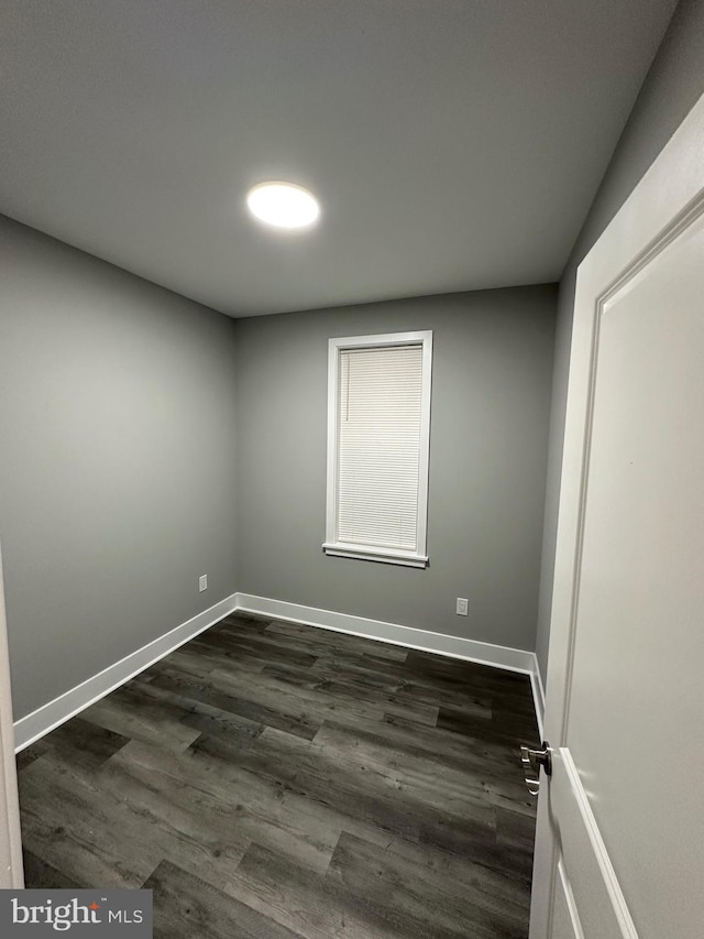 spare room featuring dark wood-type flooring