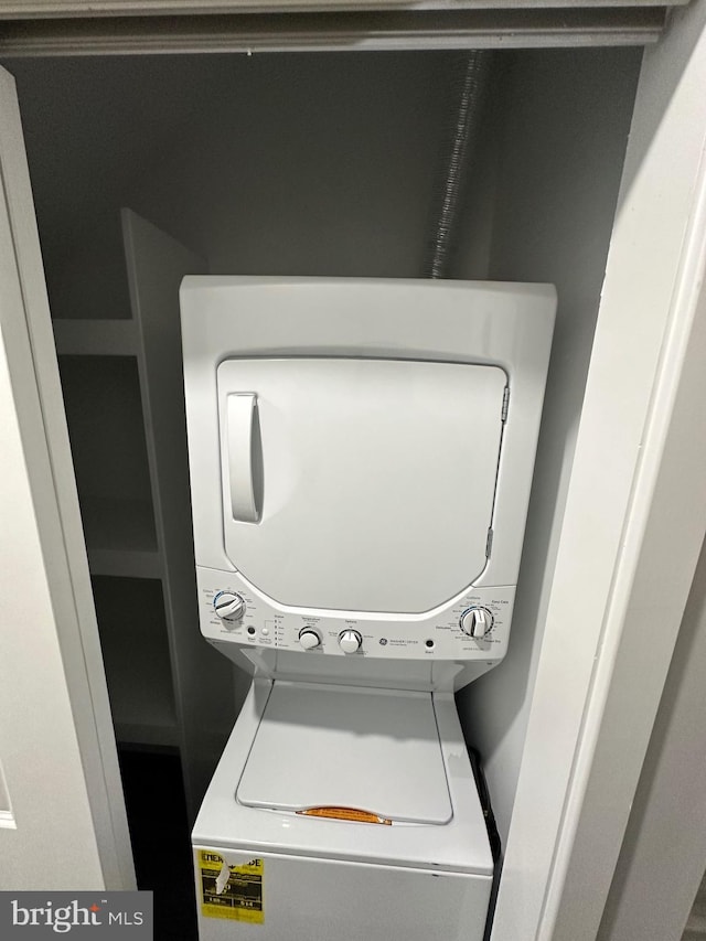 clothes washing area with stacked washer / dryer