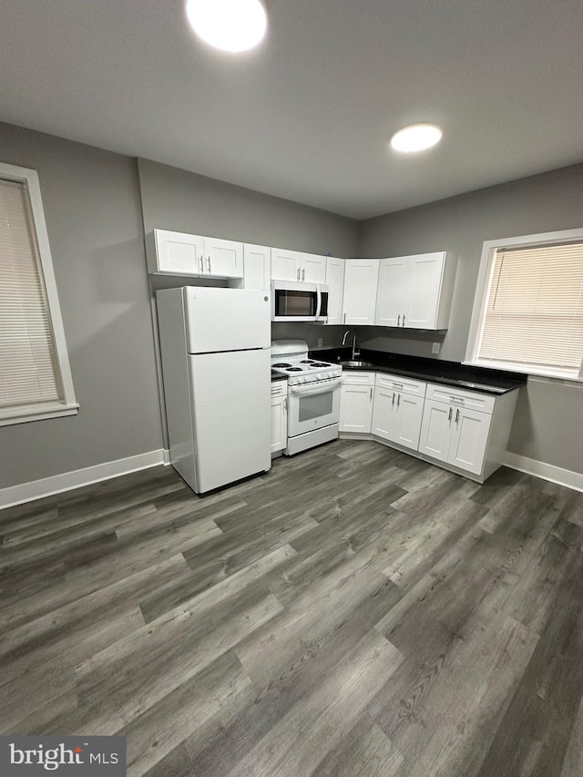 kitchen with white cabinets, white appliances, and dark hardwood / wood-style flooring