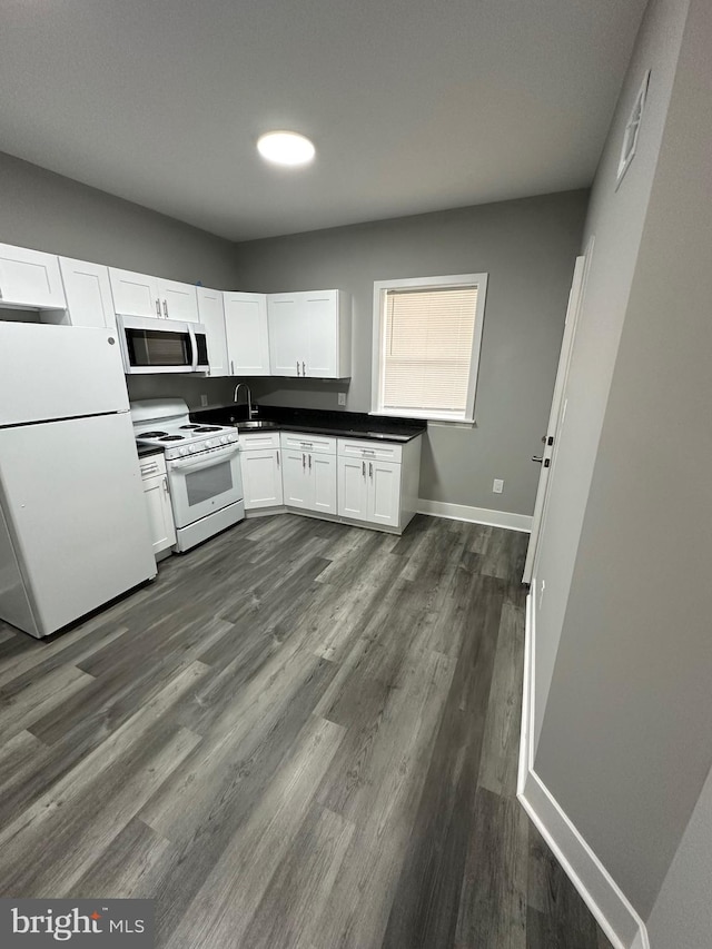 kitchen featuring white appliances, white cabinetry, sink, and dark wood-type flooring