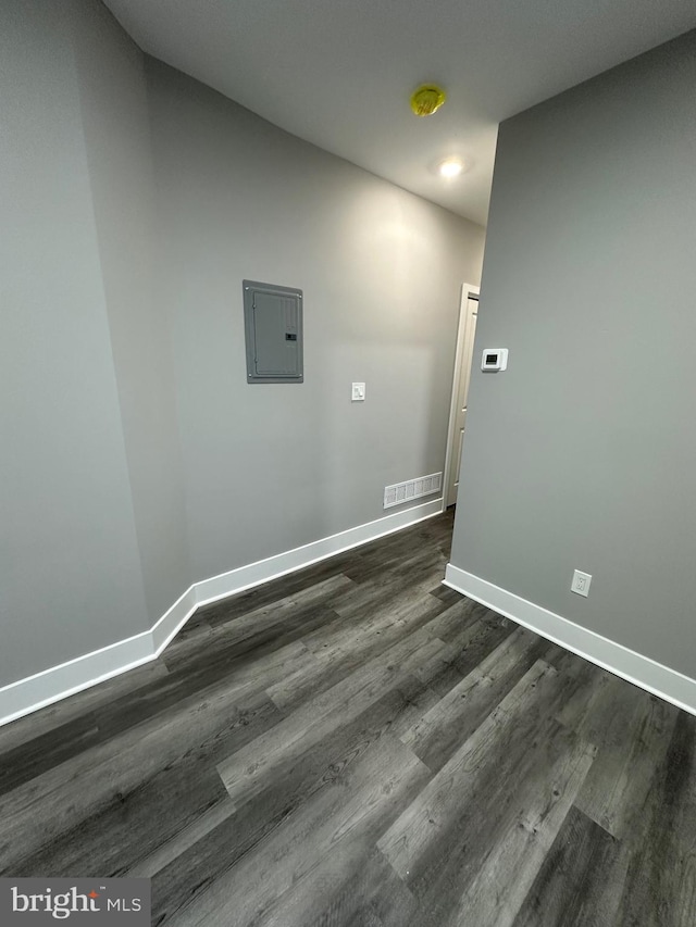 laundry area featuring electric panel and dark hardwood / wood-style floors