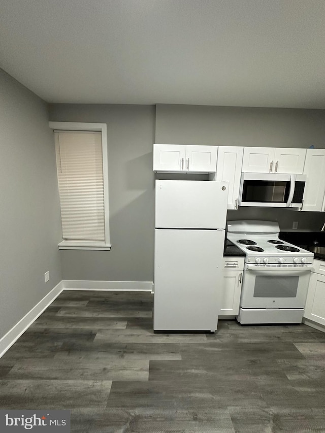 kitchen featuring white appliances, white cabinetry, and dark hardwood / wood-style flooring