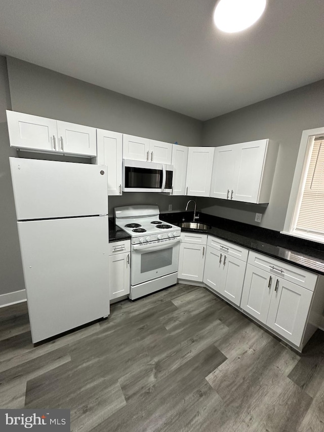 kitchen featuring sink, dark wood-type flooring, white appliances, and white cabinetry