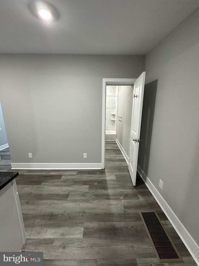 unfurnished room with dark wood-type flooring