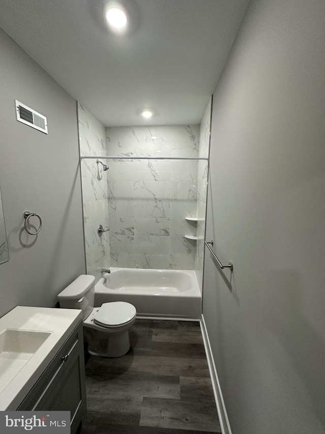 full bathroom with tiled shower / bath, vanity, toilet, and hardwood / wood-style flooring