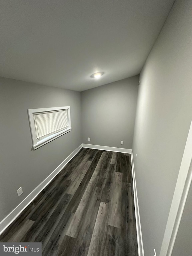 unfurnished room with dark hardwood / wood-style flooring