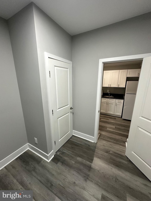 corridor featuring dark hardwood / wood-style floors and sink