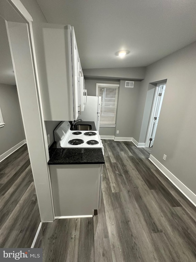 kitchen featuring white appliances, dark hardwood / wood-style flooring, and white cabinets